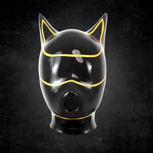 May include: A glossy black full-head mask featuring pointed cat-like ears at the top. The mask is accented with thin, vibrant yellow piping that outlines the ears, the eye area, and the circular mouth opening, creating a distinct graphic contrast.