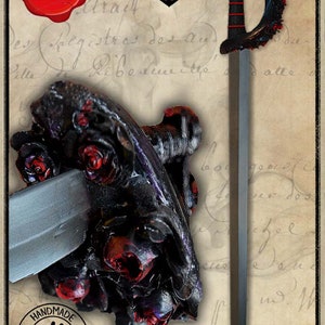 May include: A black sword with a red and black handle and a silver blade. The handle is decorated with roses and the blade is partially inserted into a black and red rose-shaped object. The sword is labeled "LATEX".