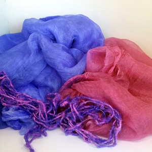 May include: Two sheer scarves, one blue and one pink, with a purple fringe.