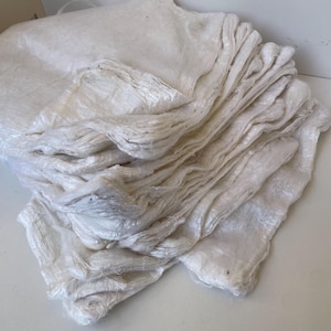 Peut inclure: Une pile de feuilles de papier rectangulaires blanc cassé faites à la main. Le papier a une surface légèrement texturée et semble être fait de fibres naturelles. Les feuilles sont superposées, montrant les bords de chaque pièce.
