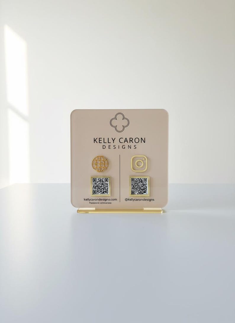 Custom acrylic QR code sign with three QR codes, gold social media icons and personalized business branding, displayed on a reflective countertop