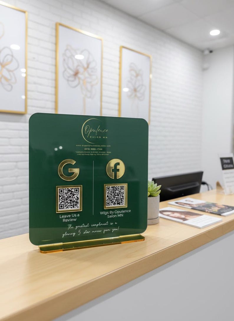 Custom acrylic QR code sign with three QR codes, gold social media icons and personalized business branding, displayed on a reflective countertop
