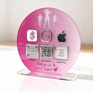 Custom acrylic QR code sign with three QR codes, gold social media icons and personalized business branding, displayed on a reflective countertop