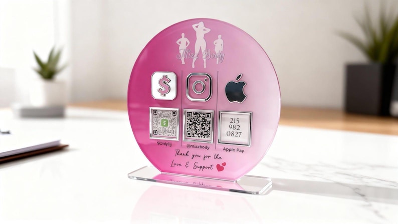 Custom acrylic QR code sign with three QR codes, gold social media icons and personalized business branding, displayed on a reflective countertop
