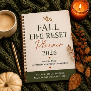 Könnte beinhalten: Ein spiralgebundener Planer mit cremefarbenem Einband und dem Text FALL LIFE RESET Planner 2026, 90-DAY RESET, SEPTEMBER OCTOBER NOVEMBER sowie REFLECT. RESET. REFOCUS. PREPARE FOR YOUR BEST 2027. Der Einband enthält kleine Blatt- und Herzsymbole.
