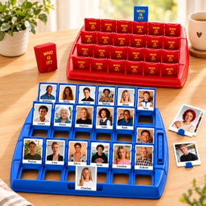 May include: A blue and red Who Is It? board game set featuring two plastic game boards with flip-up character cards. The blue board displays various portraits with names like Dawson, Emily, and Charles, while the red board has matching red covers.
