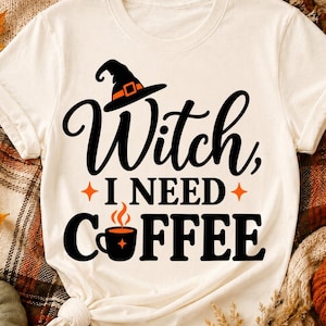 Op de afbeelding: Een crèmekleurig t-shirt met korte mouwen en zwarte tekst die Witch, I NEED COFFEE leest. Het ontwerp bevat een zwarte heksenhoed met een oranje band boven het woord Witch en een zwarte koffiemok met oranje stoom boven het woord COFFEE.