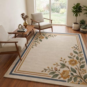 May include: A rectangular area rug featuring a cream-colored base with a border of thin blue and gold lines. The rug is decorated with large, raised floral motifs in shades of yellow and green, positioned in the corners of the design.