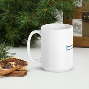 Peut inclure: Un mug en céramique blanche avec une ligne bleue verticale à côté du texte noir Running and Artificial. Le mug possède une anse standard et un corps cylindrique, présenté comme un récipient fonctionnel pour les boissons chaudes ou froides.
