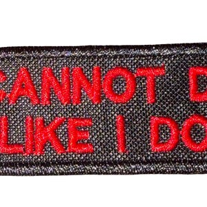 May include: A rectangular black embroidered patch with a stitched border. The text AI CANNOT DO IT LIKE I DO. is embroidered in red thread across the center of the patch in a bold, sans-serif font, spanning two lines of text.