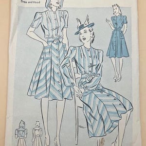 May include: An Advance sewing pattern envelope 2471 for a dress and hood, size 12, bust 30, hip 33. The white paper envelope features blue line illustrations of a button-front dress with striped fabric, a tie waist, and a matching hood.