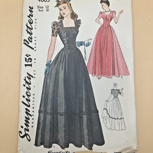 Może przedstawiać: Koperta z wykrojem krawieckim Simplicity 4065, rozmiar 12, biust 30. Ilustracja przedstawia suknię do ziemi z kwadratowym dekoltem, krótkimi koronkowymi rękawami i pełną spódnicą z koronkowym wykończeniem. Druga wersja sukni jest pokazana w kolorze różowym.
