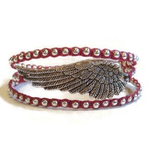 May include: A red leather wrap bracelet with silver beads and a silver angel wing charm.