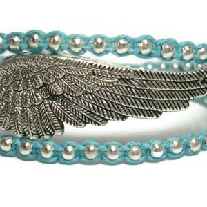 Puede incluir: Un brazalete de envoltura de cuentas turquesa con un dije de ala de plata. El brazalete est&aacute; hecho de m&uacute;ltiples hebras de cord&oacute;n turquesa con cuentas de plata.