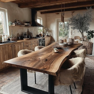 Könnte beinhalten: Ein großer Esstisch aus Holz mit natürlicher Baumkante, ausgeprägter Maserung und dunkelbraunem Finish, getragen von zwei schwarzen, U-förmigen Metallbeinen. Der Tisch ist von vier Stühlen mit strukturiertem, beigem, zotteligem Stoffbezug umgeben.