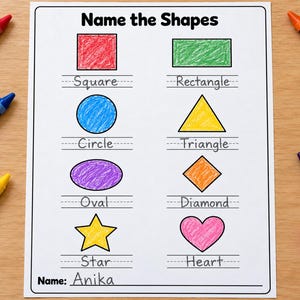 May include: A white educational worksheet titled Name the Shapes featuring eight hand-colored shapes including a red square, green rectangle, blue circle, yellow triangle, purple oval, orange diamond, yellow star, and pink heart with the name Anika.