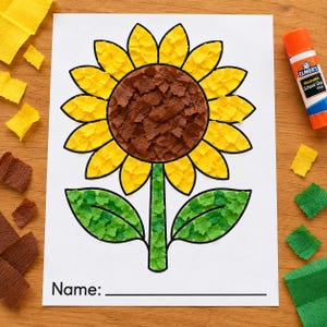 May include: A craft project on white paper featuring a sunflower made of torn yellow, brown, and green crepe paper pieces. The flower has a brown center, yellow petals, and green leaves on a stem. An orange Elmer's glue stick is visible nearby.