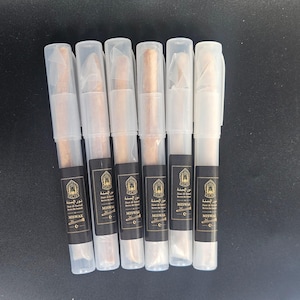 May include: Six cylindrical miswak sticks encased in individual clear plastic protective tubes with white caps. Each tube features a black rectangular label with gold text reading Noor Al-Sunnah, Revive the Sunnah, and MISWAK with an icon.