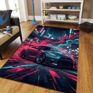 Può includere: Un tappeto rettangolare raffigurante un'auto sportiva scura che guida attraverso una strada cittadina illuminata al neon di notte. Il design include scie luminose rosa e ciano, edifici urbani luminosi e una prospettiva dinamica del veicolo.