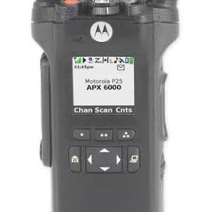 May include: A black Motorola APX 6000 P25 portable two-way radio featuring a long antenna, a top-mounted control knob, and a digital display screen showing the text Motorola P25 APX 6000, Chan, Scan, and Cnts with various status icons.