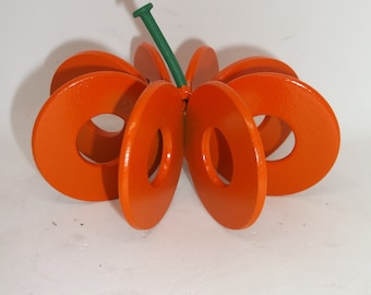 Op de afbeelding: Een oranje houten pompoendecoratie. De pompoen is gemaakt van verschillende oranje, cirkelvormige stukken, met een groene steel en spijker. Dit decoratieve item is perfect voor de herfst en Halloween.