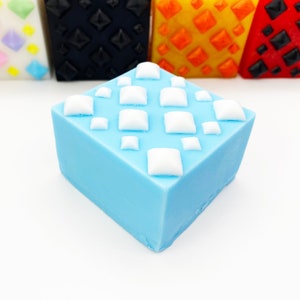 May include: A light blue square soap bar with a white diamond pattern.
