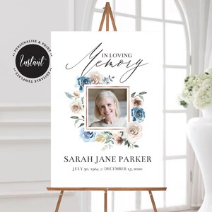 Puede incluir: Un cartel conmemorativo blanco con una corona de flores azul y beige que rodea una foto de una mujer. El texto "In Loving Memory" está escrito en cursiva sobre la foto. El texto "Sarah Jane Parker" está escrito debajo de la foto, seguido de las fechas "July 30, 1964 - December 15, 2020".