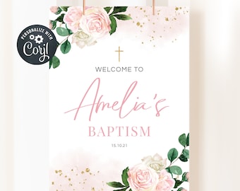 May include: A white sign with pink watercolor background and gold glitter accents. The sign says "Welcome to Amelia's Baptism 15.10.21" with a gold cross at the top and floral designs on the sides.