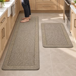 May include: A set of two rectangular kitchen floor mats featuring a tan and black vertical striped pattern with a solid border. The mats have rounded corners and a low-profile texture, designed for placement on a kitchen floor surface.