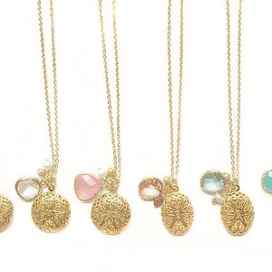 May include: Five gold necklaces with different coloured gemstone pendants and intricate gold filigree charms. Each necklace features a round, ornate gold pendant.