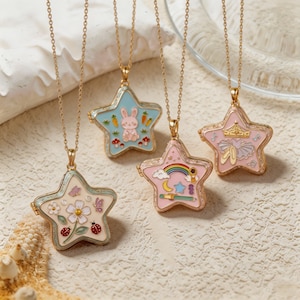 Può includere: Quattro medaglioni in metallo dorato a forma di stella su sottili catenine d'oro. Uno presenta un fiore, farfalle e coccinelle. Un altro mostra un coniglio e carote su sfondo blu. Un terzo mostra un arcobaleno, una luna e una stella. Il quarto raffigura una corona e scarpette da danza.