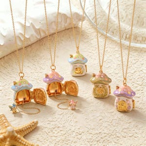 May include: Five gold-tone chain necklaces featuring mushroom-shaped locket pendants. The pendants have pastel-coloured caps with white spots and detailed house designs. Some lockets are open, revealing interior details and small attached charms.