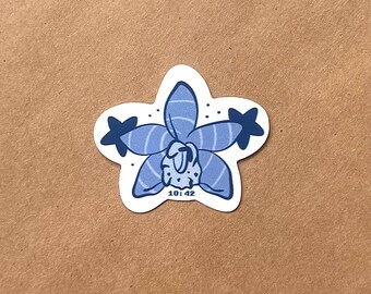 May include: A die-cut sticker featuring a stylized blue orchid flower with five petals, two dark blue star-shaped accents on the sides, and the text 10:42 printed in dark blue at the bottom center. The design has a white border and a flat graphic style.