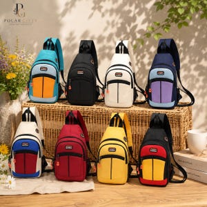 May include: Eight sling backpacks arranged in two rows, featuring various color combinations including teal and orange, solid black, off-white, navy and purple, white and blue, solid red, solid yellow, and black with red and yellow accents.