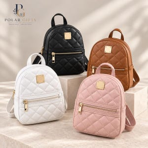 Könnte beinhalten: Vier kleine Rucksäcke in Schwarz, Weiß, Braun und Hellrosa. Jeder Rucksack hat ein gestepptes Rautenmuster, einen Tragegriff, eine vordere Reißverschlusstasche und eine quadratische goldfarbene Metallplatte. Das Logo Polar Gifts ist sichtbar.