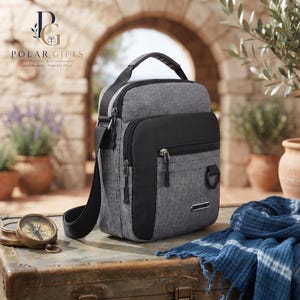 May include: A grey and black crossbody bag with a top handle, multiple zippered compartments, and a small metal D-ring on the front. The bag features a textured fabric finish, black nylon straps, and a small rectangular metal logo plate labeled JINGPIN.