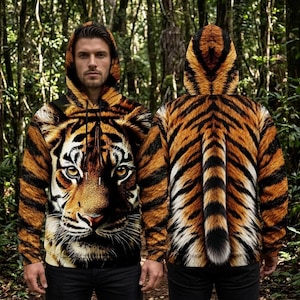 Pode incluir: Uma camisola de manga comprida com capuz apresentando uma estampa realista de rosto de tigre na frente e um padrão de listras de tigre nas costas, incluindo um gráfico de uma cauda de tigre centralizado nas costas e cordões pretos no decote.