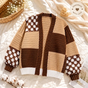 May include: A long-sleeve crochet cardigan featuring a color-blocked pattern of tan and dark brown panels. The sleeves and upper front panels display a white floral motif on a dark brown background. It has a ribbed collar and a white hem.