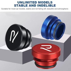 Könnte beinhalten: Drei zylindrische Metallknöpfe für den Autoinnenraum in Schwarz, Blau und Rot. Jeder Knopf hat ein weißes stilisiertes Logo auf der Oberseite und einen schwarzen Gummi-O-Ring an der Basis. Der Text UNLIMITED MODELS STABLE AND INDELIBLE ist sichtbar.