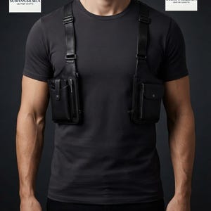 Op de afbeelding: Een zwart lederen borstharnas met twee symmetrische opbergvakken met drukknoopsluitingen en verstelbare schouderbanden. Het harnas wordt gedragen over een effen donkergrijs T-shirt. Het logo SUBHAN.SILSILA LEATHER CRAFTS is zichtbaar.