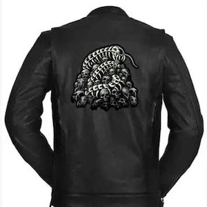 May include: A black leather jacket featuring a large graphic on the back. The design depicts a segmented centipede-like creature crawling over a pile of human skulls, rendered in high-contrast black and white tones on the back panel.