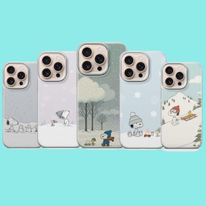 May include: Five smartphone cases featuring Snoopy and Woodstock in various winter scenes. The designs include snowy landscapes, trees, a campfire, and sledding activities, all rendered in soft pastel colors with a clear protective finish.