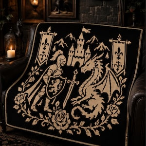 May include: A black and cream woven throw blanket featuring a pixelated design of a knight in armor with a shield, a dragon, a castle, and two banners with fleur-de-lis symbols. The scene is framed by a border of roses and foliage.