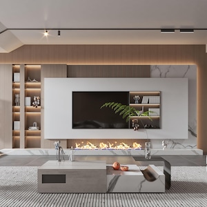 Op de afbeelding: Een woonkamer met een groot wit wandmeubel met een ingebouwde televisie, geïntegreerde planken en een lineaire haard. De kamer bevat een lage rechthoekige salontafel, een donkere fauteuil en een witte poef op een vloerkleed.