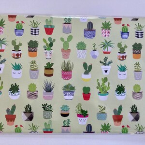 May include: A green wrapping paper with a repeating pattern of potted succulents in various colors and styles. The succulents are in different shapes and sizes, with some having flowers or other decorative elements.