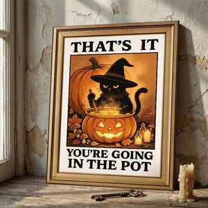 May include: A framed wall art print featuring a black cat wearing a witch hat, stirring a glowing jack-o'-lantern pot. The text reads THAT'S IT YOU'RE GOING IN THE POT. The illustration includes a large pumpkin, autumn leaves, mushrooms, and candles.