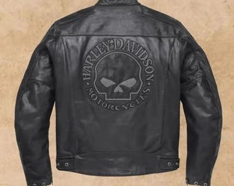 May include: A black leather motorcycle jacket featuring a mandarin collar and long sleeves. The back displays a large, embossed circular graphic with a skull design in the center and the text Harley-Davidson Motorcycles encircling the skull.