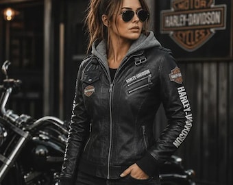 May include: A black leather jacket featuring a gray hooded insert, a full-length front zipper, and multiple zippered pockets. The jacket displays Harley-Davidson branding on the chest, sleeve, and shoulder patches, with ribbed cuffs and hem.