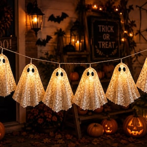 Peut inclure: Une guirlande de six lumières en forme de fantômes, chacune dotée d'une texture blanche semblable à de la dentelle et de deux yeux ovales noirs. Les fantômes sont reliés par un fil fin, diffusant une lueur jaune chaude pour un décor festif.