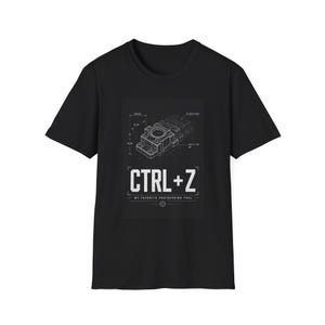 Puede incluir: Una camiseta negra de manga corta con un estampado gráfico blanco de un dibujo técnico de ingeniería de una pieza mecánica. Debajo del dibujo, el texto dice CTRL+Z y MY FAVORITE ENGINEERING TOOL, con un pequeño icono de engranaje en la parte inferior.